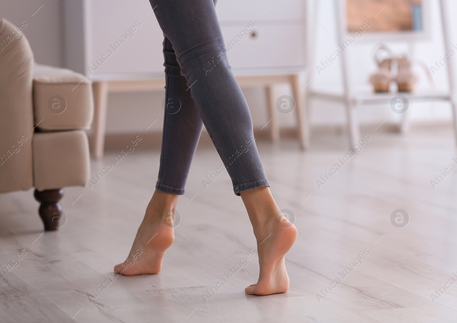 Photo of Young woman walking barefoot at home, closeup. Heating concept