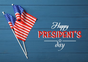 Happy President's Day - federal holiday. American flags and text on blue wooden table, flat lay