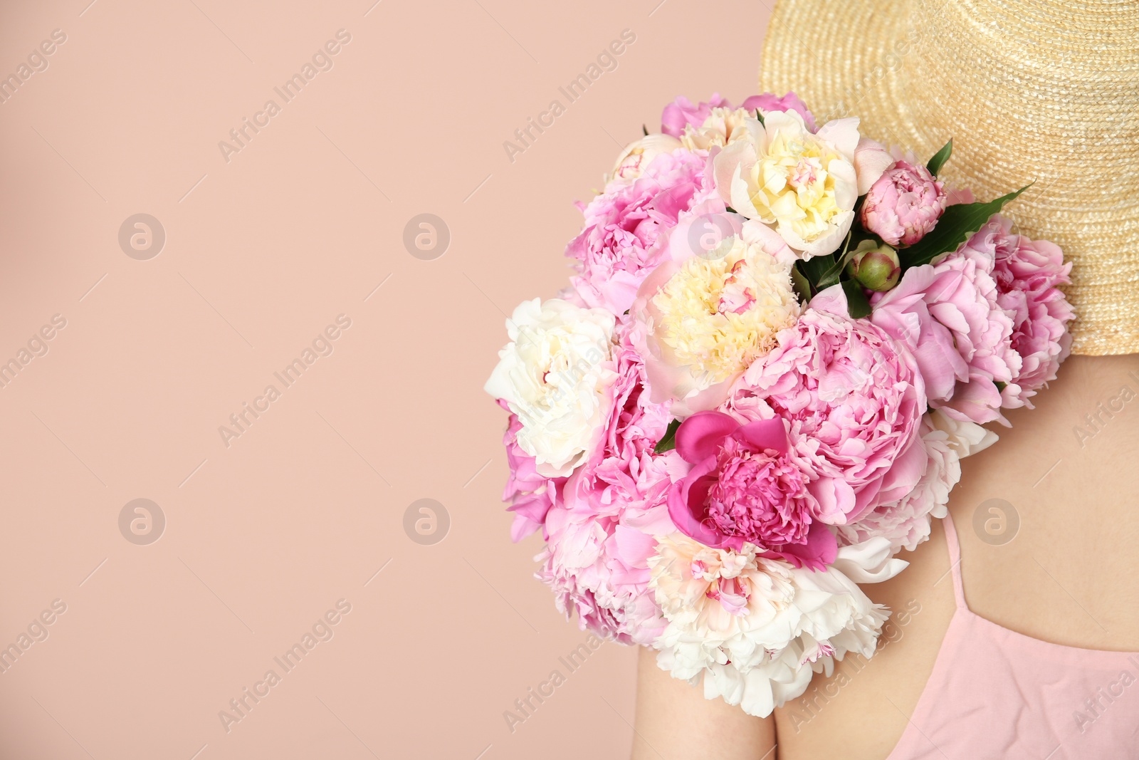 Photo of Woman with bouquet of beautiful peonies on beige background, closeup. Space for text