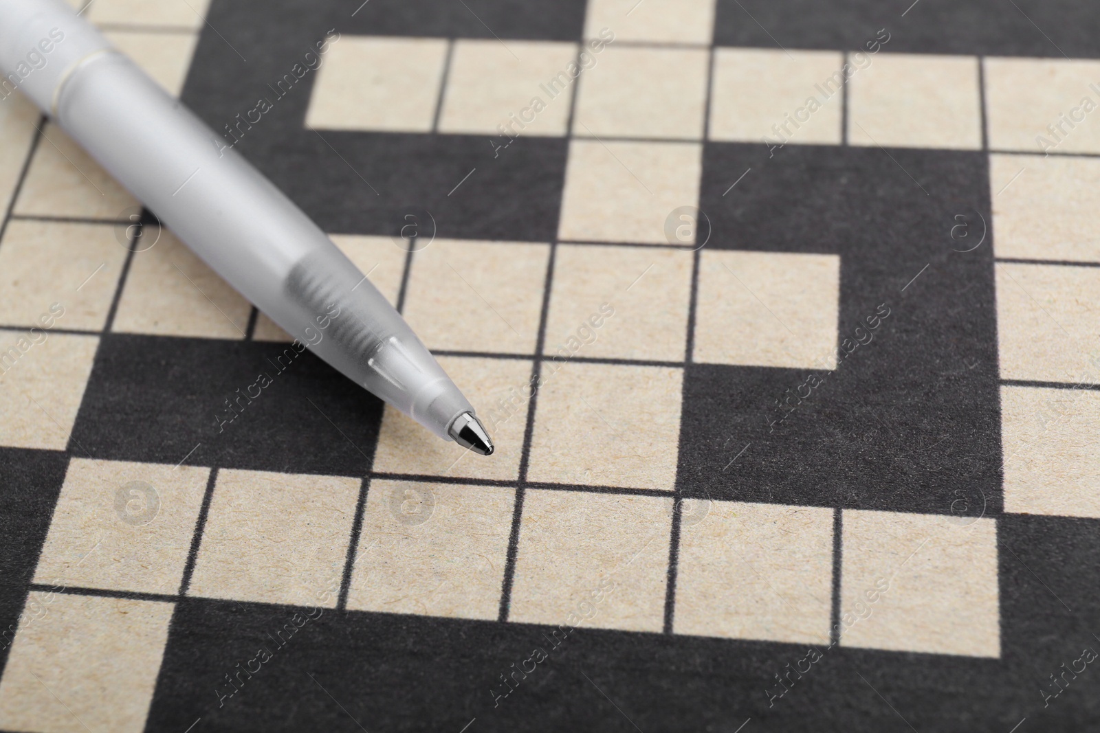 Photo of Pen on blank crossword, closeup. Space for text