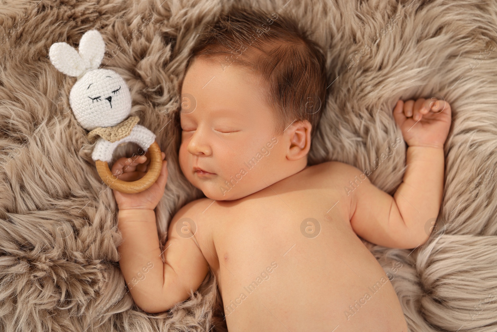 Photo of Cute newborn baby sleeping with toy on fluffy blanket, top view