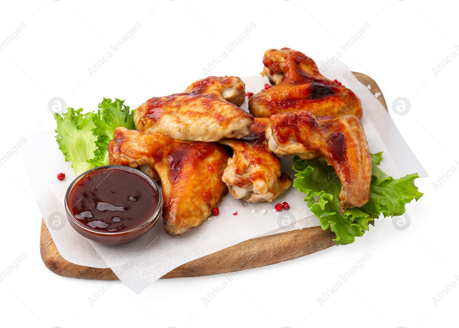 Photo of Board with marinade, chicken wings, spices and lettuce isolated on white