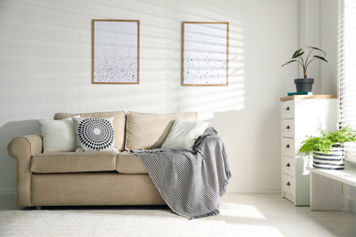 Photo of Stylish decorative pillows on beige couch indoors