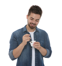 Photo of Happy young man with yogurt and spoon on white background