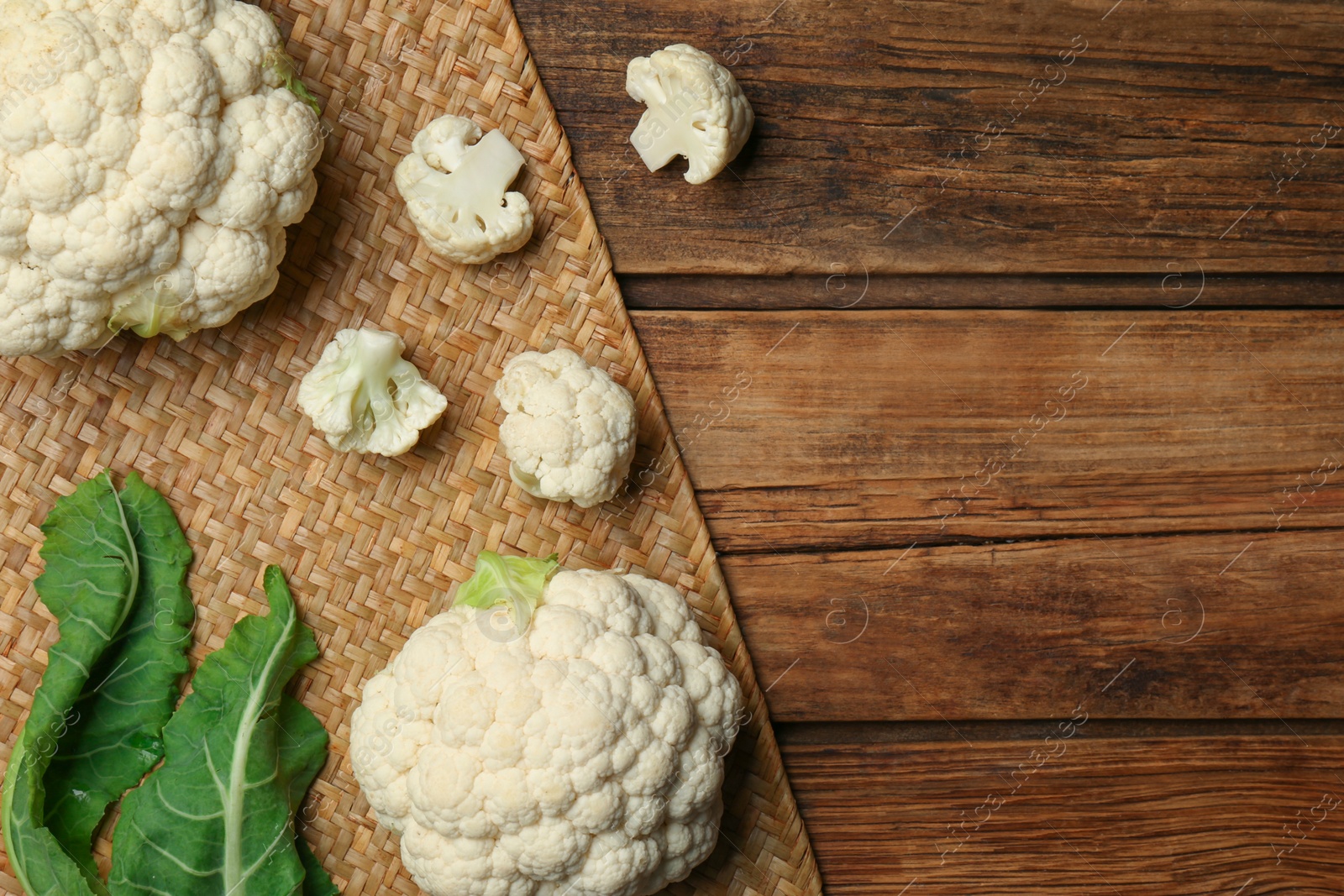 Photo of Fresh cauliflower on wooden table, top view. Space for text