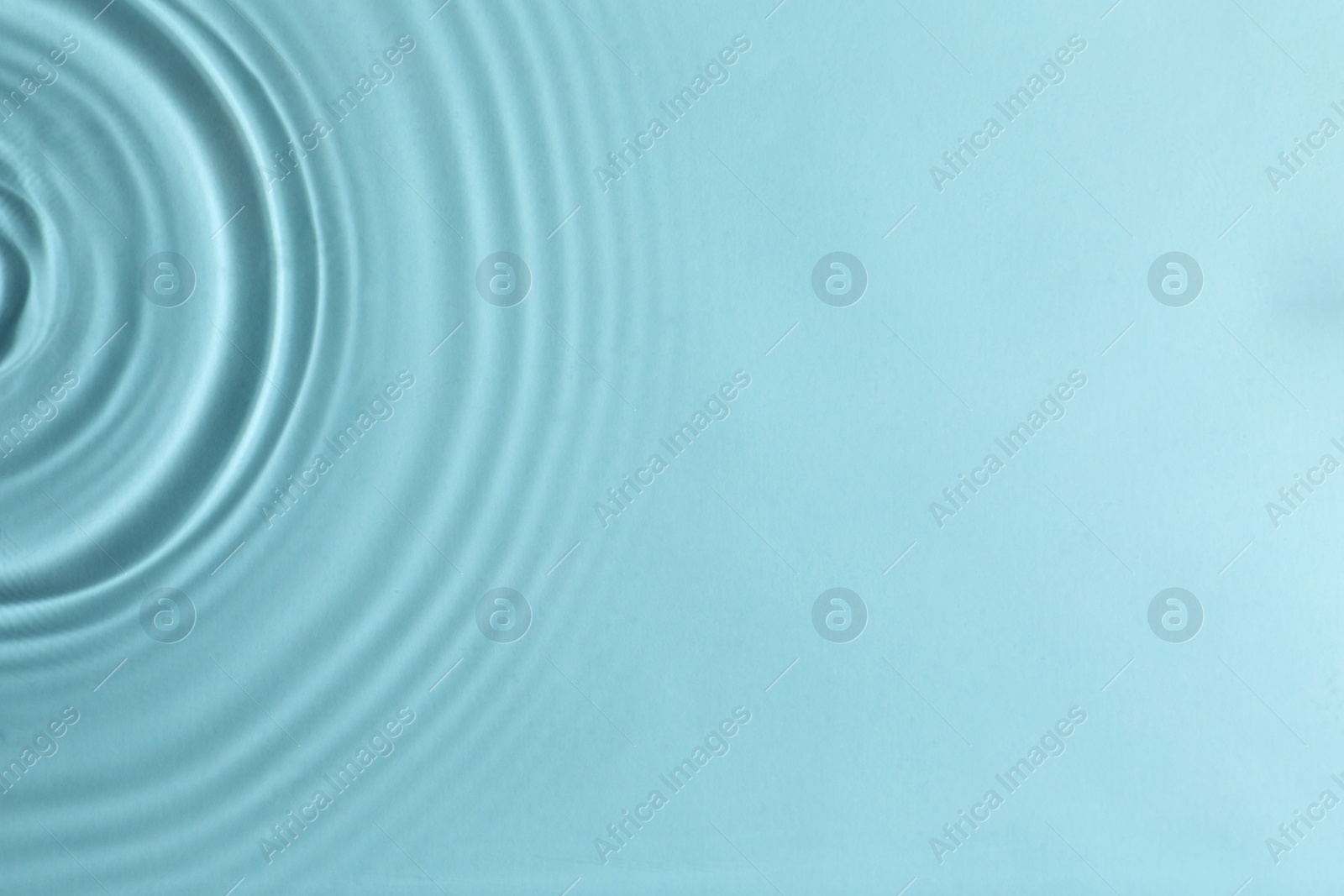 Photo of Closeup view of water with circles on turquoise background. Space for text