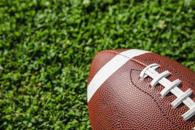 Photo of Ball for American football on fresh green field grass