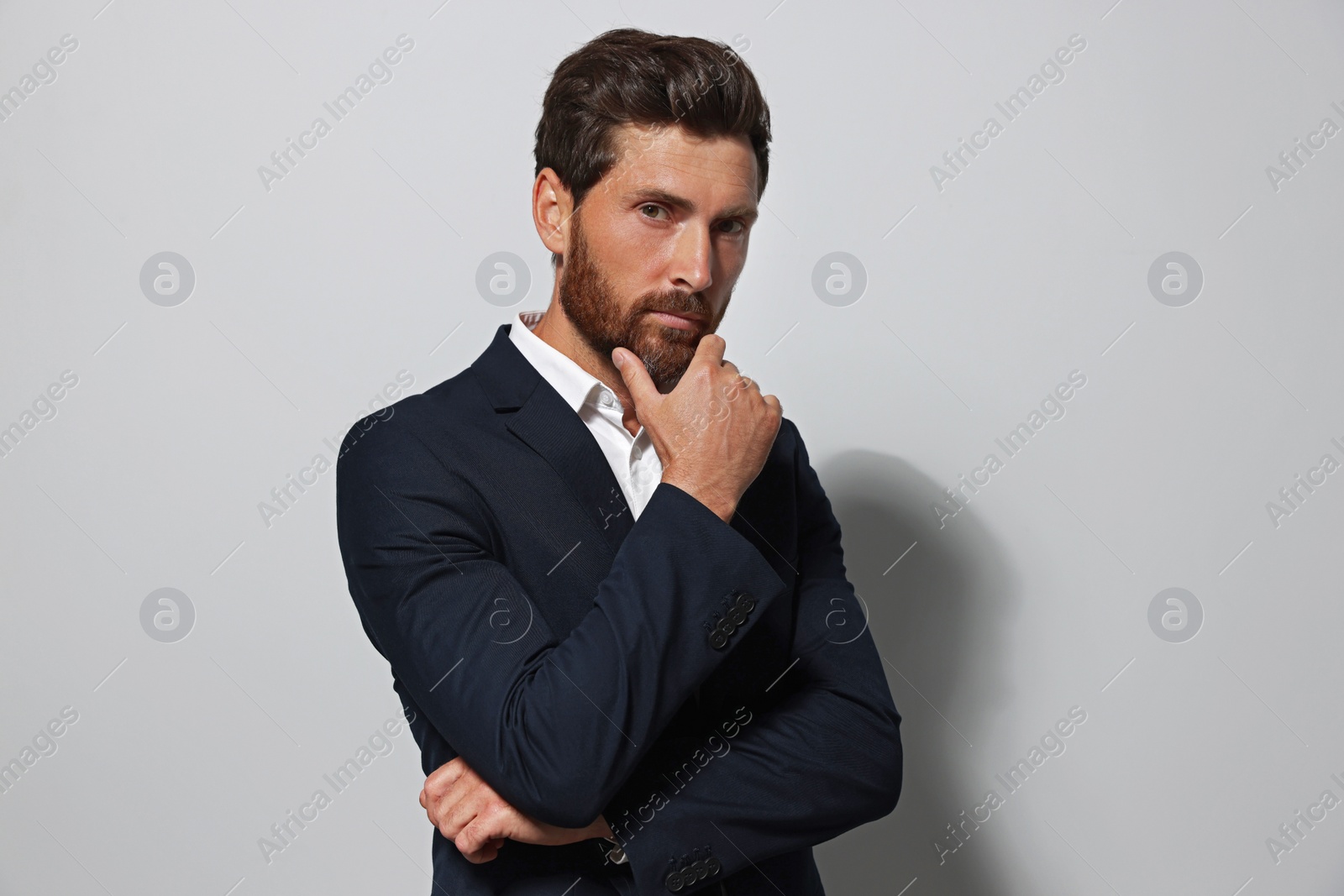 Photo of Portrait of handsome bearded man in suit on light grey background