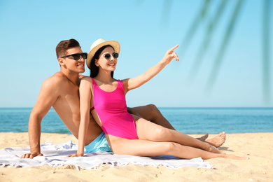 Happy couple resting on sunny beach at resort