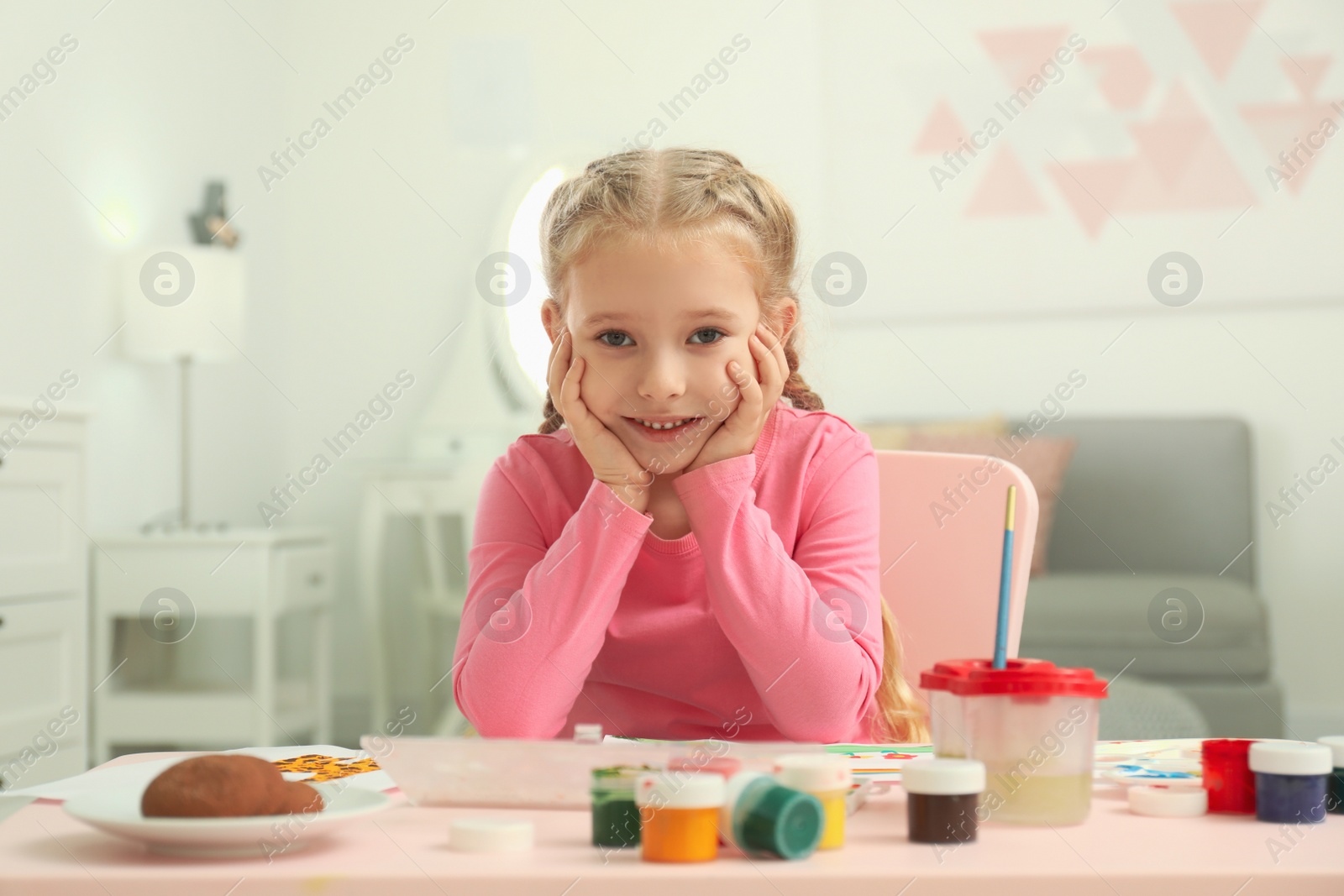 Photo of Cute little child painting at table in room