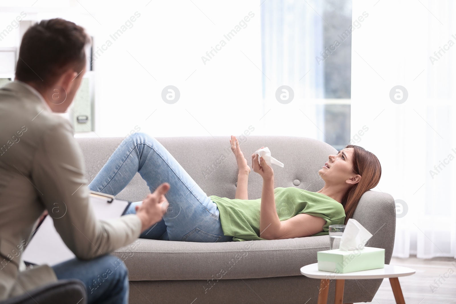 Photo of Psychotherapist working with woman in light office