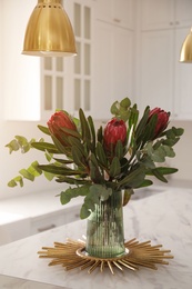 Bouquet with beautiful protea flowers on table in kitchen. Interior design