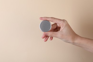 Photo of Woman with lip balm on beige background, closeup