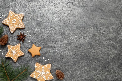 Photo of Tasty Christmas cookies, fir branches, cones and anise on grey table, flat lay. Space for text