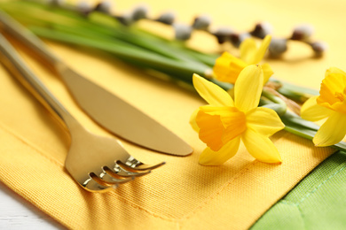Photo of Cutlery set with floral decor on table, closeup. Easter celebration