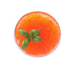 Photo of Bowl of delicious red caviar and basil isolated on white, top view