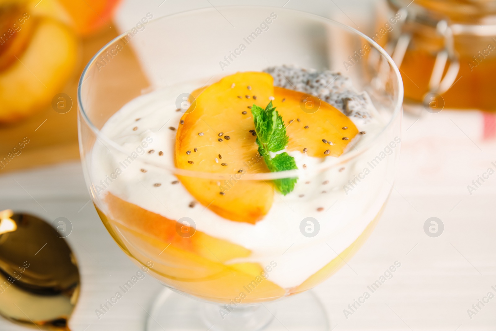 Photo of Tasty peach dessert with yogurt and chia seeds served on white table, closeup