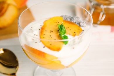 Photo of Tasty peach dessert with yogurt and chia seeds served on white table, closeup