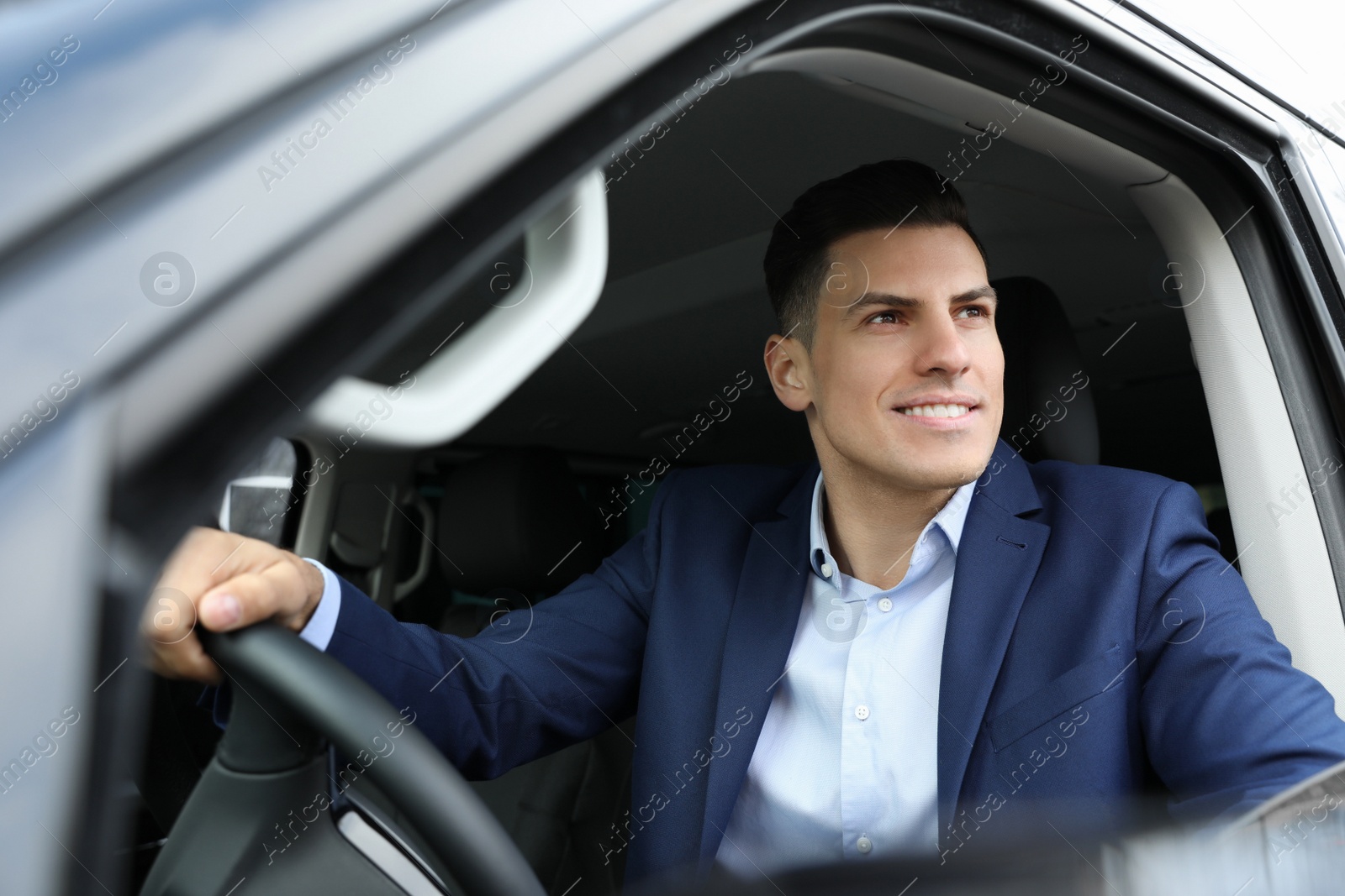 Photo of Handsome man driving his modern car, view from outside