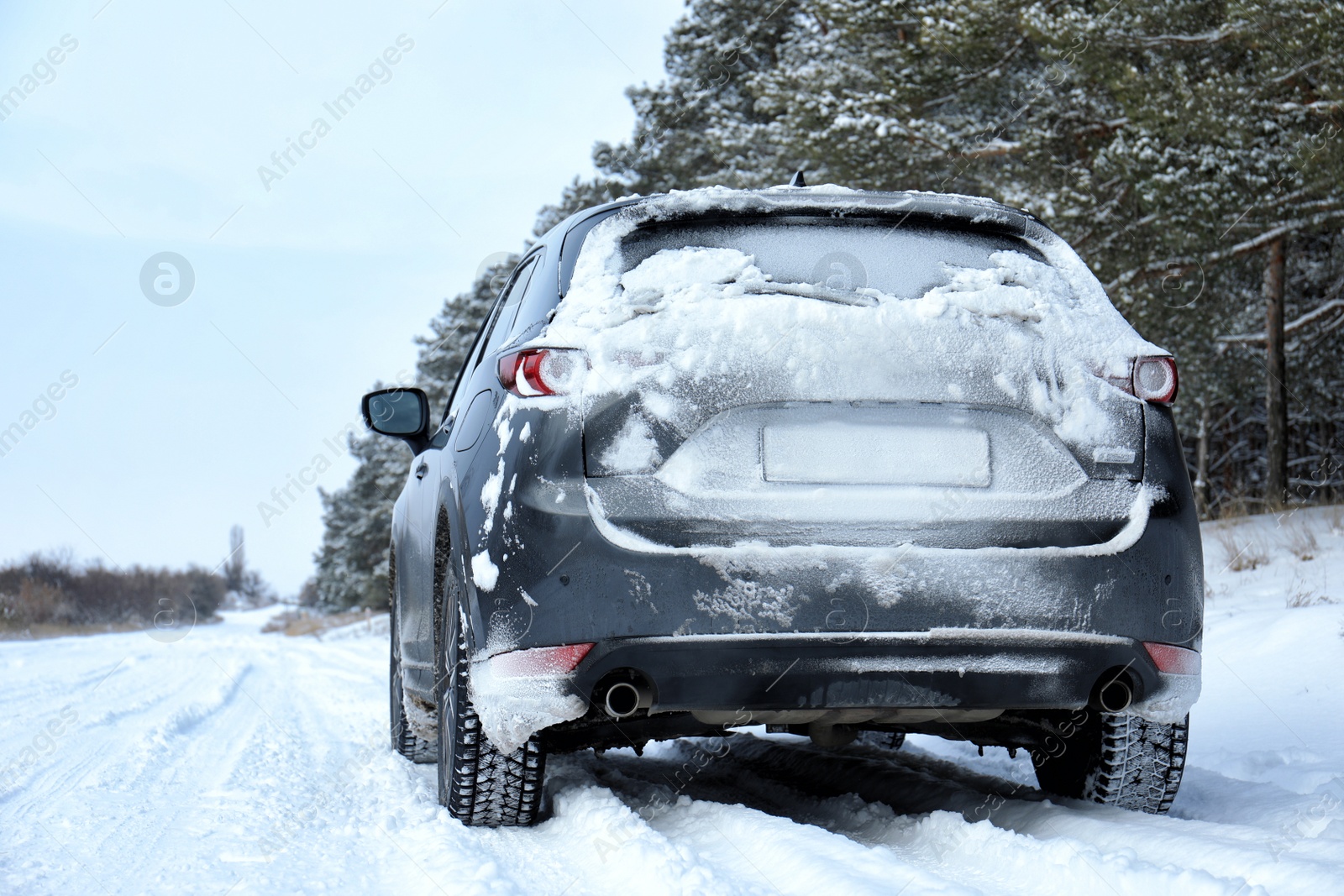 Photo of Snowy country road with car on winter day