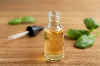 Glass bottle of essential oil on wooden table