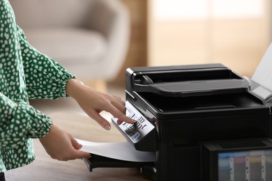Photo of Woman using modern printer in office, closeup