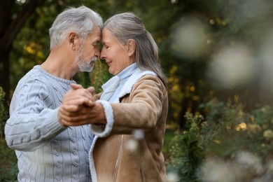 Photo of Affectionate senior couple dancing together outdoors, space for text. Romantic date