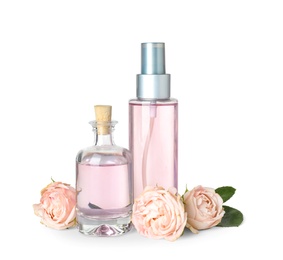 Photo of Bottles of essential oil and roses on white background
