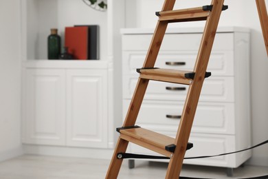 Photo of Wooden folding ladder in stylish living room