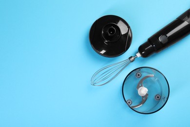Photo of Hand blender kit. Whisk, lid, bowl and bowl chopper on light blue background, flat lay. Space for text