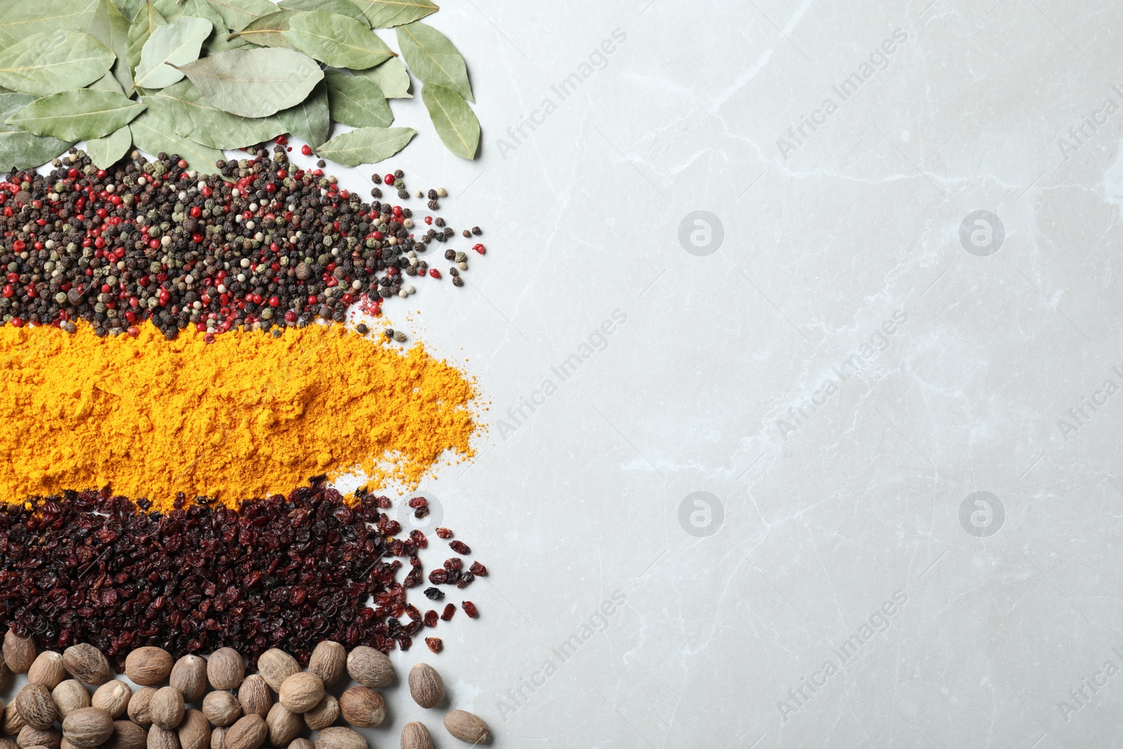 Photo of Many different spices on marble background, top view. Space for text
