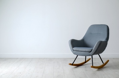 Photo of Stylish comfortable armchair near light wall indoors