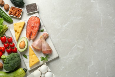 Photo of Flat lay composition with keto diet products on light grey marble table, space for text