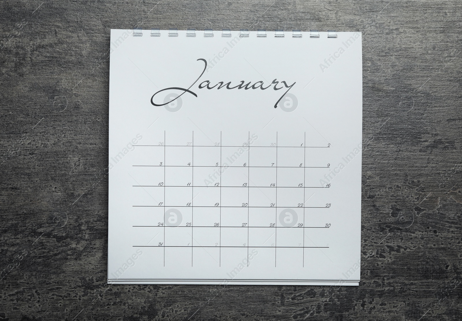 Photo of January calendar on grey stone background, top view