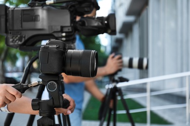 Photo of Professional video camera operators working on city street