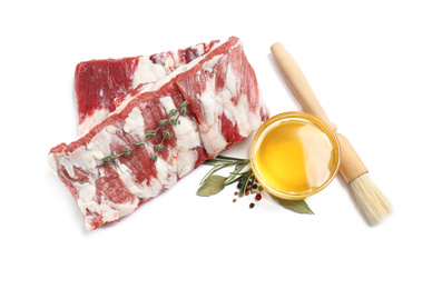 Photo of Raw ribs with herbs and oil on white background, top view