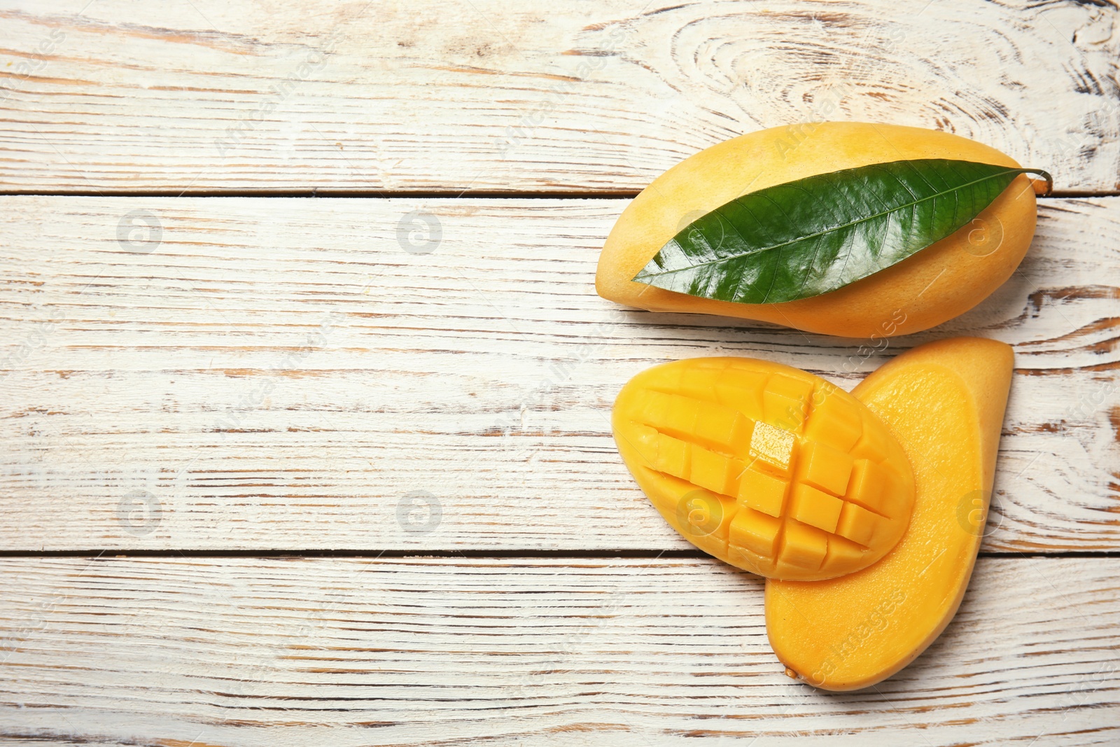 Photo of Flat lay composition with mango fruits on wooden background. Space for text