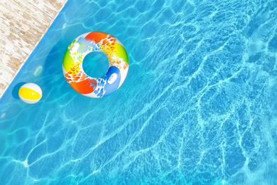 Image of Swimming pool with inflatable ring and ball, top view. Space for text