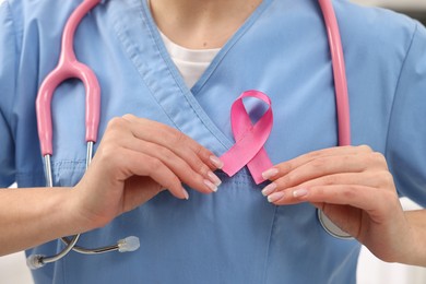 Photo of Mammologist with pink ribbon in hospital, closeup. Breast cancer awareness