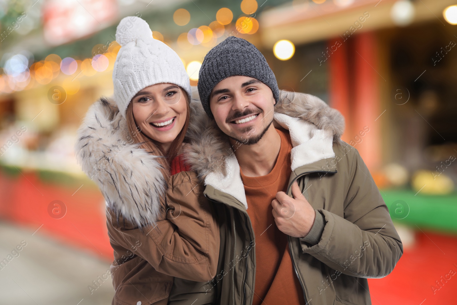 Image of Happy couple at Christmas fair. Bokeh effect