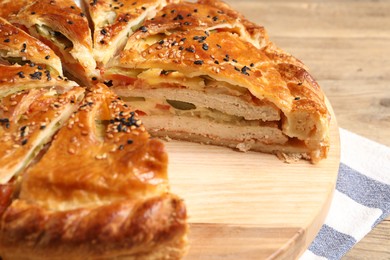Photo of Cut delicious homemade pie on wooden table, closeup