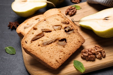 Photo of Tasty cut pear bread on black table, closeup. Homemade cake