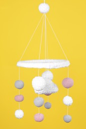 Photo of Cute baby crib mobile on yellow background