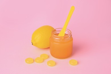Photo of Cough drops, fresh orange and honey on pink background