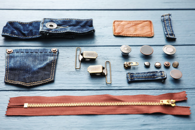 Photo of Composition with garment accessories and cutting details for jeans on light blue wooden background