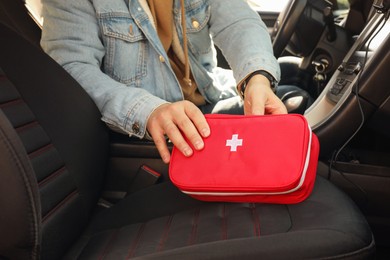 Man with first aid kit inside car, closeup