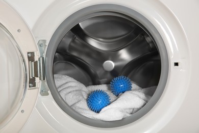 Photo of Blue dryer balls and towel in washing machine drum