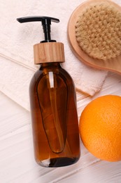 Photo of Cosmetic product, orange and brush on white wooden table, flat lay. Anti cellulite treatment