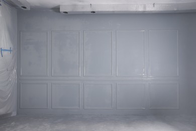Photo of Grey fresh painted wall with frames in room