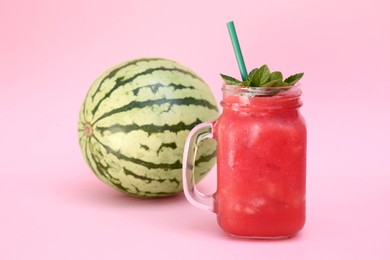 Photo of Glass of delicious drink with mint and fresh watermelon on pink background